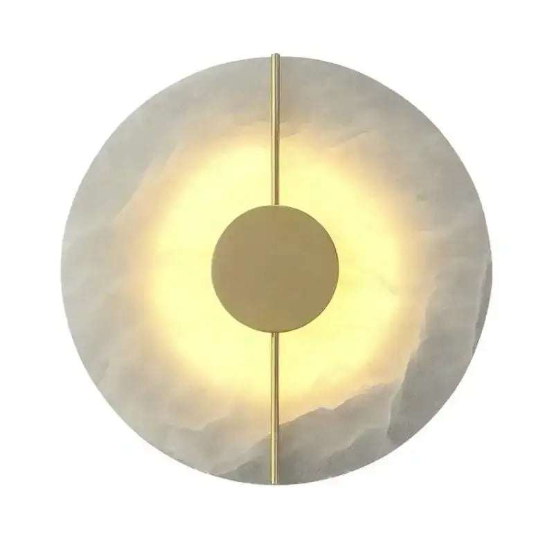 Modern circular decorbites lumind copper wall lamp with textured white stone face and polished brass accents emitting warm light