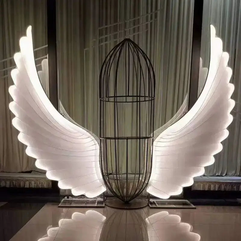 A decorbites luminescent angel wings led lamp with glowing white led wings and a black wire cage body for modern decor