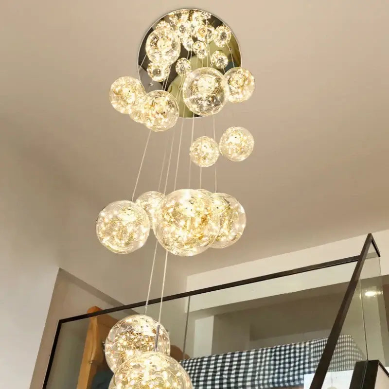A modern decorbites luminous glass ball pendant chandelier with spherical glass orbs emitting warm golden light