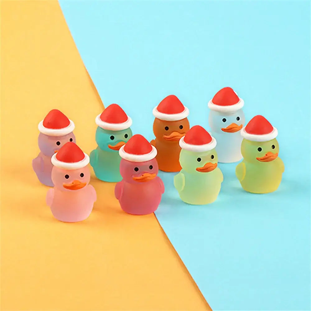 A collection of colorful translucent rubber duck figurines with red santa hats in decorbites luminous resin cactus miniatures set