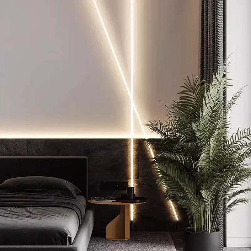 A tall lush green palm plant in a sleek black pot beside decorbites luminous silicone wall lamp neon light