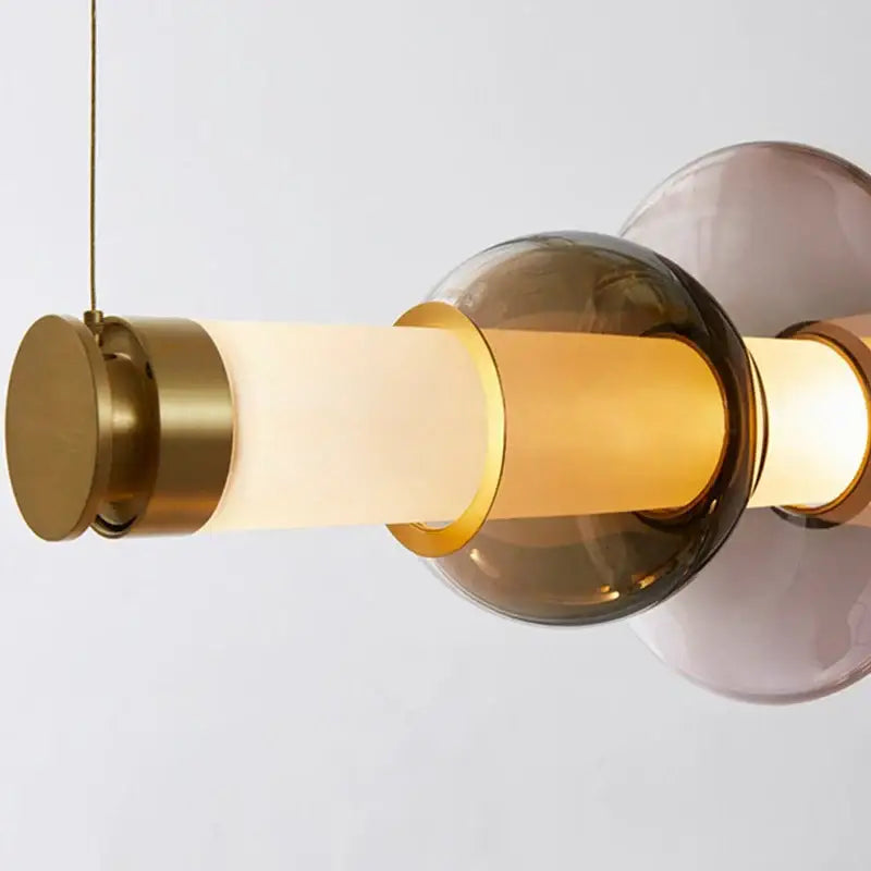 Modern luna glass tube chandelier with brass accents frosted glass tubes amber and muted purple orbs for kitchen dining