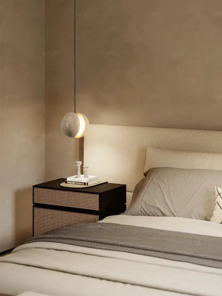 A modern decorbites lunar stone pendant chandelier with a spherical matte stone shade hanging from a thin cord for home lighting