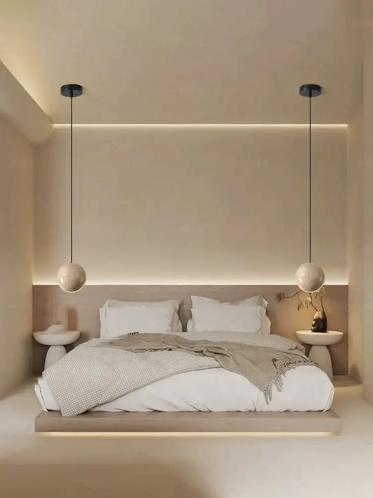 Minimalist bedroom with decorbites lunar stone pendant chandelier featuring two matte black spherical lights above bed