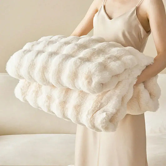 A plush off-white decorbites luxe faux rabbit fur throw blanket with soft textured surface and rolled edges for cozy use