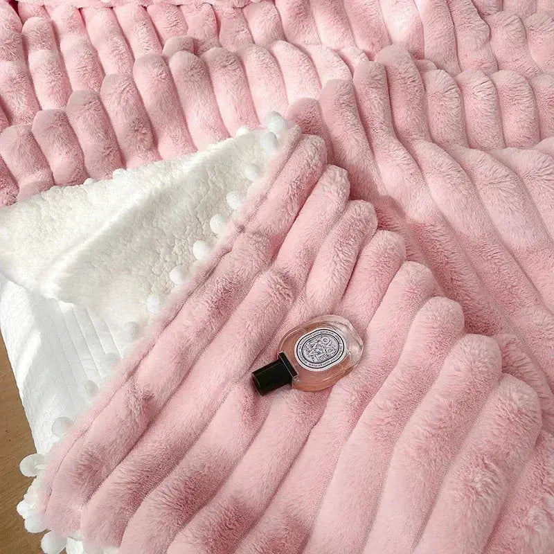 Decorbites luxe faux rabbit fur weighted double blanket in pink with ribbed texture and white pom-pom trim for cozy warmth