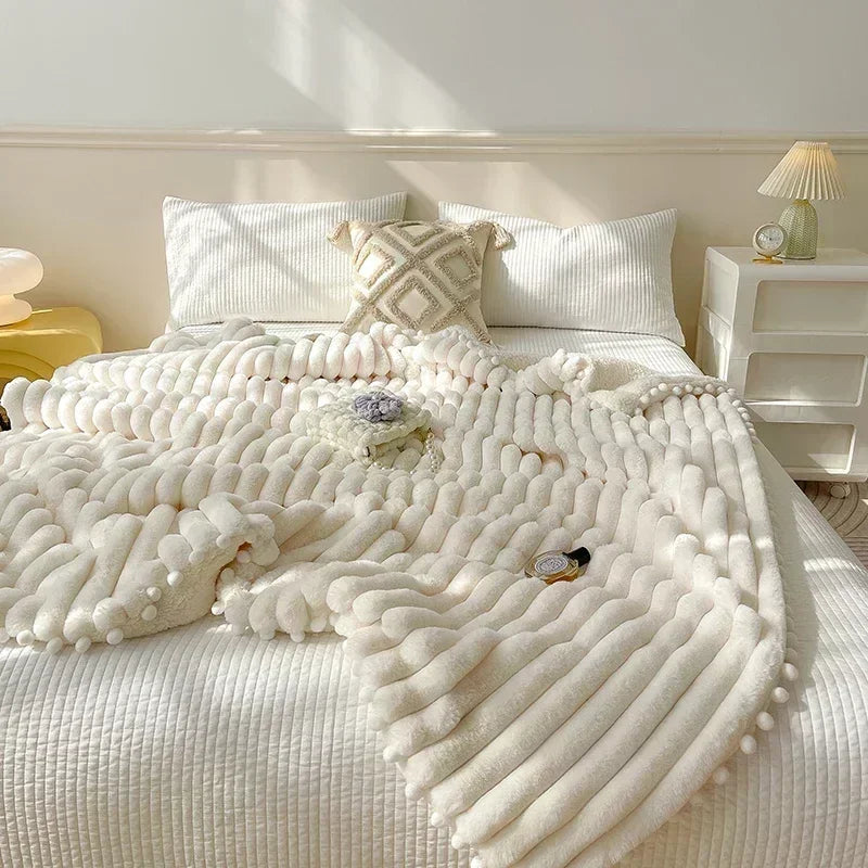 Cream-colored chunky knit weighted blanket with pom-poms featuring luxe faux rabbit and lambs wool for warmth