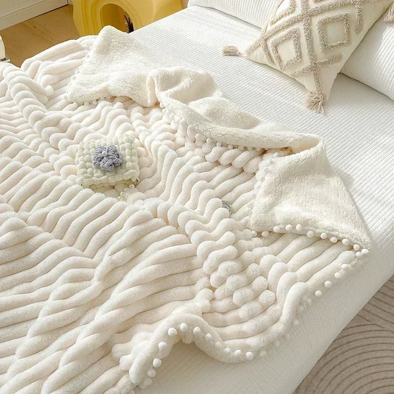 Cream-colored luxe faux rabbit weighted blanket with diamond pattern and white pom-poms for cozy autumn winter warmth
