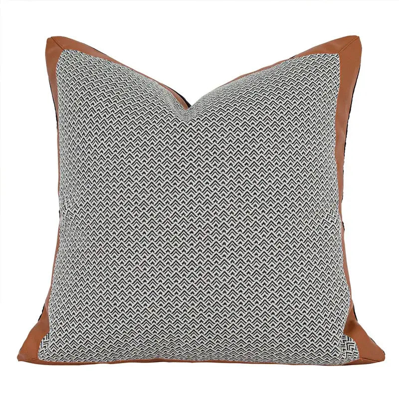 Square throw pillow with gray and black herringbone pattern framed by tan leather trim from decorbites luxe flannelette cushion covers