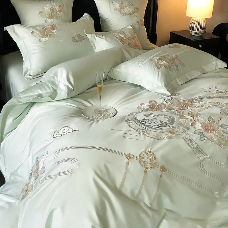 Luxurious light green satin bedding set with intricate pink peach silver floral embroidery and gold tassels by DecorBites Luxe Floral