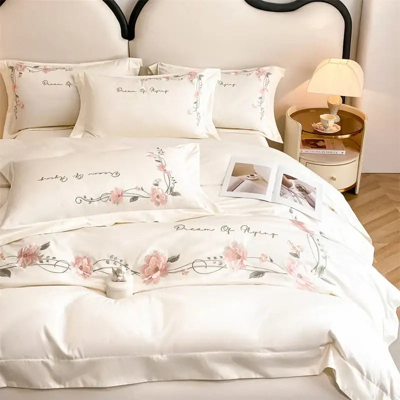 Cream-colored 100% cotton bedding set with delicate pink floral embroidery and dream of flying phrase by decorbites luxe floral