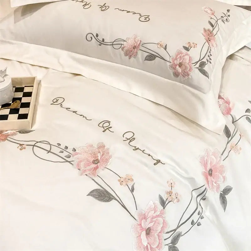 White 100% cotton bedding set with delicate pink luxe floral embroidery and elegant cursive script by DecorBites™