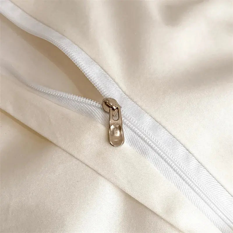 Cream-colored satin pillowcase with metallic gold zipper pull from DecorBites Luxe Floral embroidery bedding set