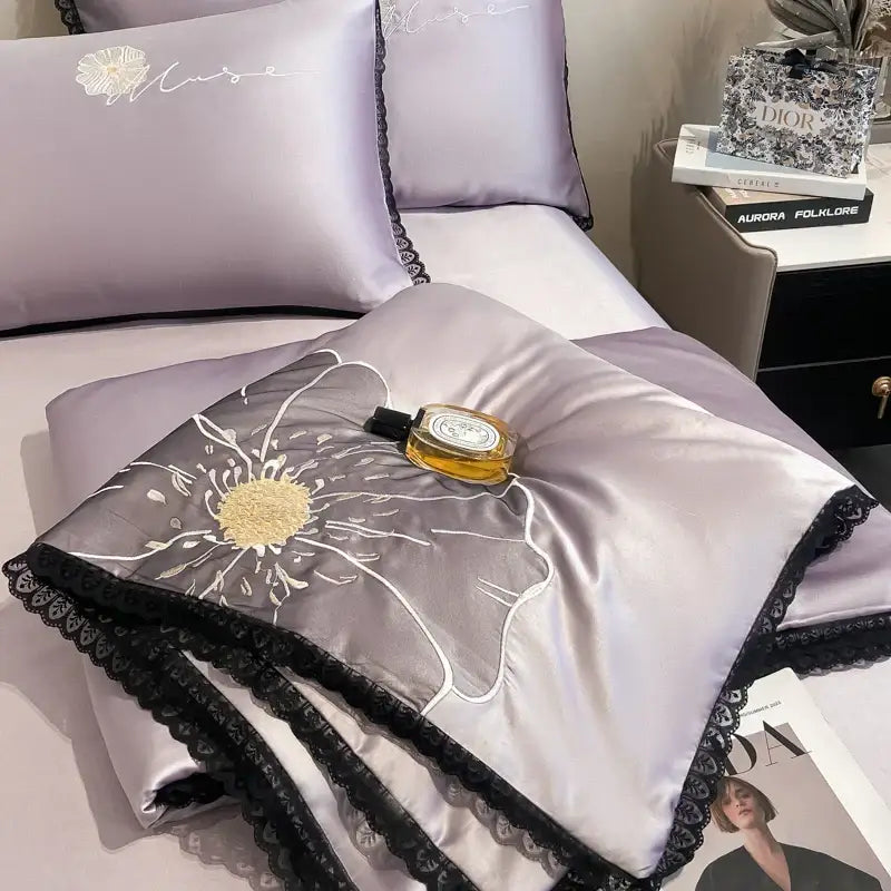 Lavender satin quilt set with black lace trim and large white flower embroidered in gold center by decorbites luxe flower