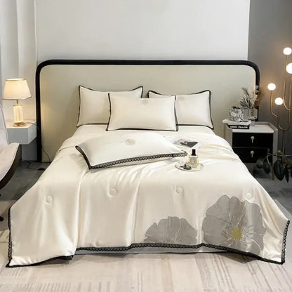 Elegant ivory satin quilt set with subtle silver floral embroidery and black scalloped trim by decorbites luxe flower
