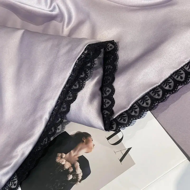 A soft lavender satin sleepwear piece with delicate black lace trim featured in the decorbites luxe flower quilt set