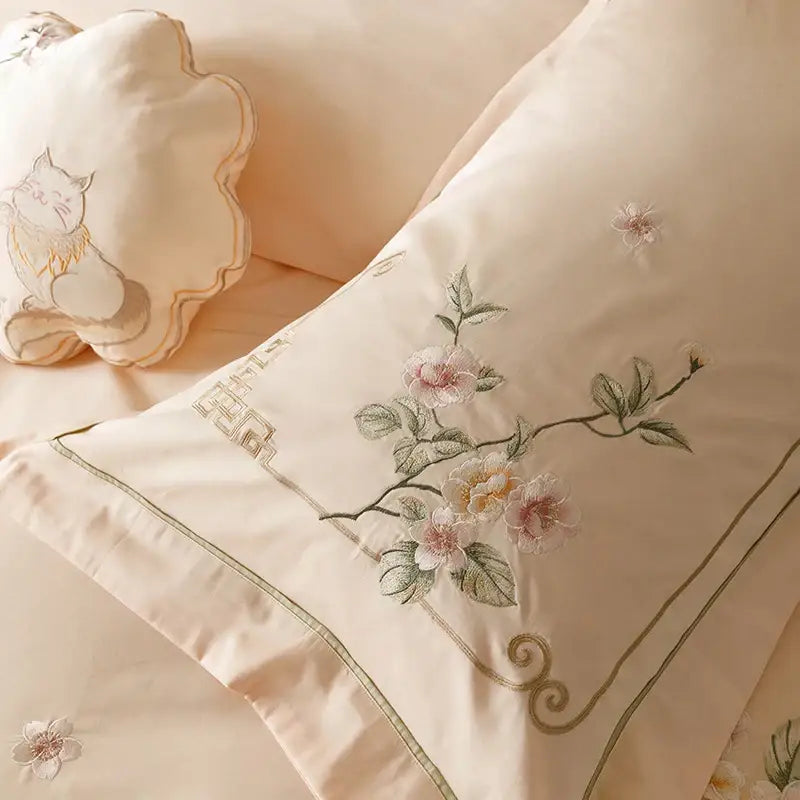 Cream-colored satin pillowcase with pink and white floral embroidery and scroll border from decorbites luxe flowers egyptian cotton bedding set
