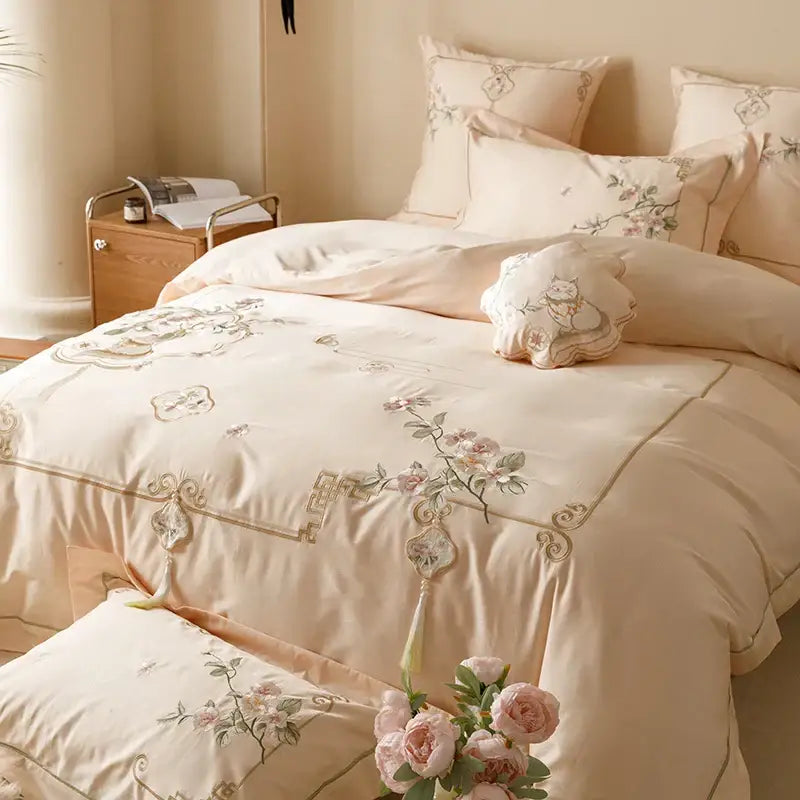 Cream-colored satin duvet cover with floral embroidery and gold tassels in decorbites luxe flowers egyptian cotton bedding set