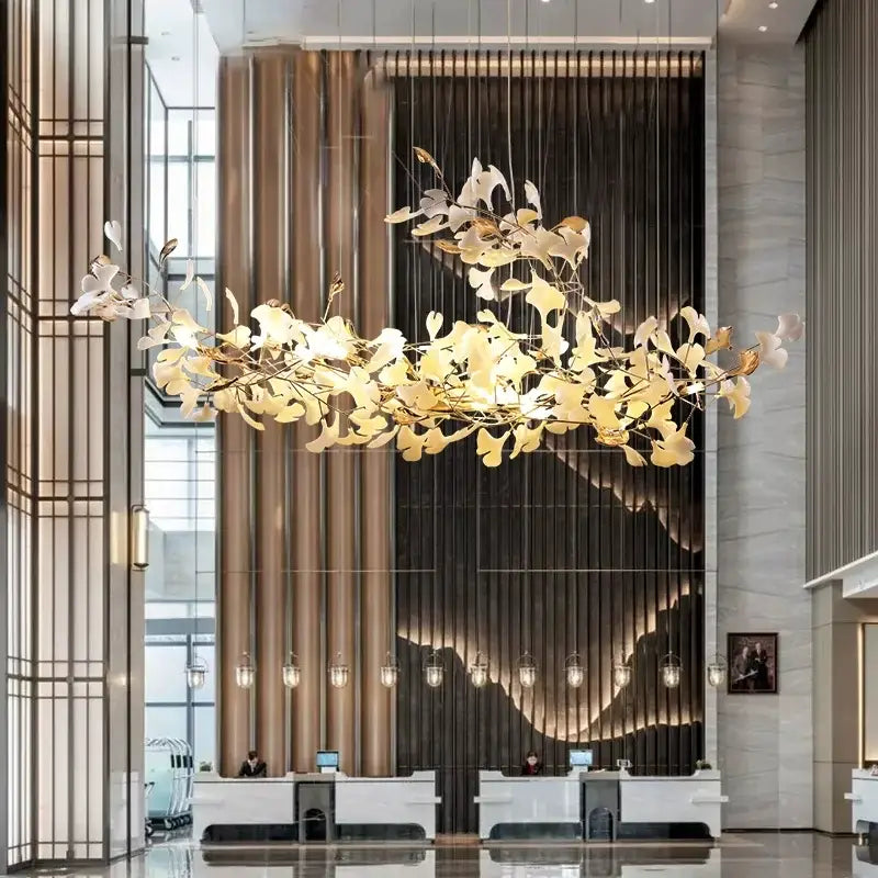 A golden metal pendant light with intricate leaf-shaped metalwork from decorbites luxe ginkgo leaves chandelier