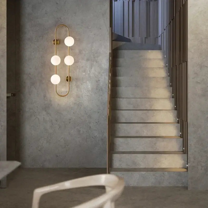 Gold-toned decorbites luxe glass ball wall sconce with five frosted bulbs for modern bedroom and living room lighting