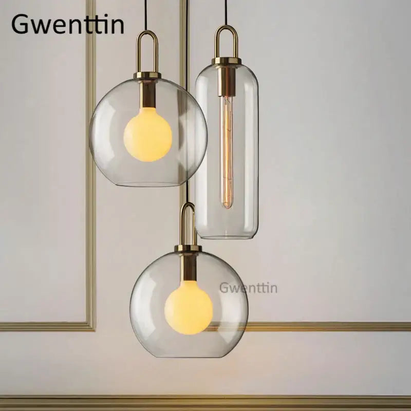 Modern brass-finished decorbites luxe glass ball pendant lights with clear glass shades and warm-toned led bulbs