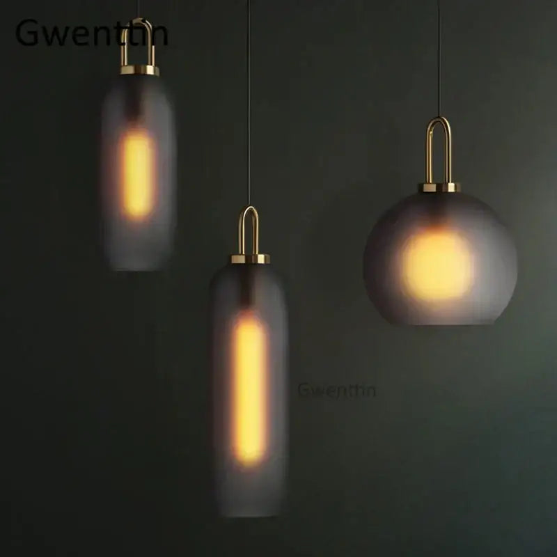 Three modern decorbites luxe glass ball pendant lights with frosted glass and brass finish emitting warm glow