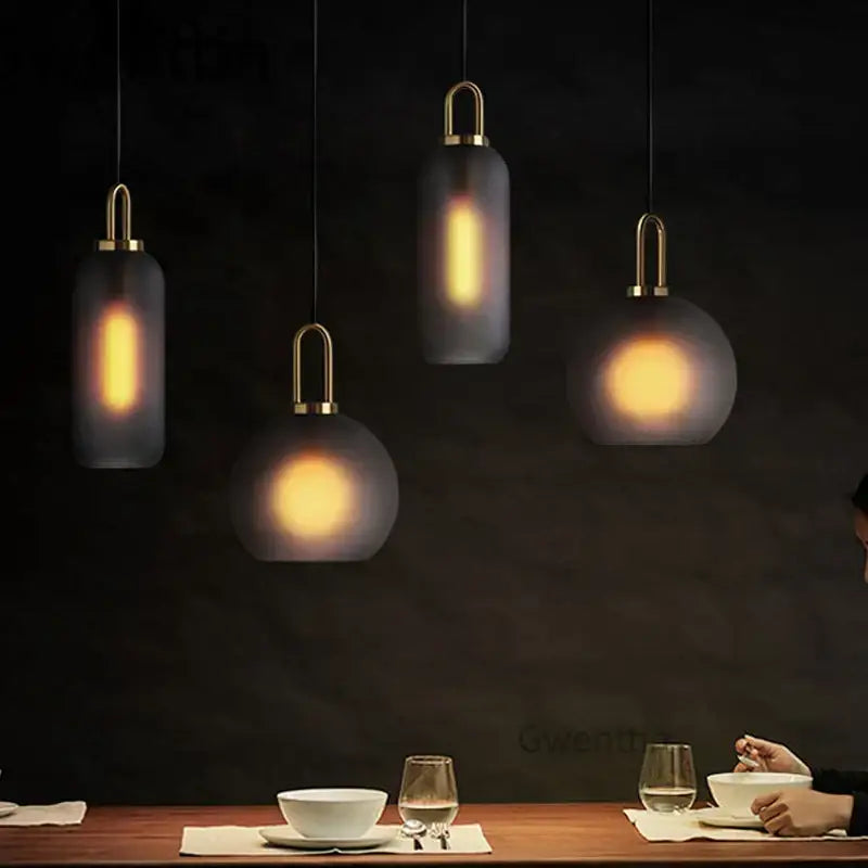 Modern decorbites luxe glass ball pendant lights with frosted glass shades and brass accents above dining table