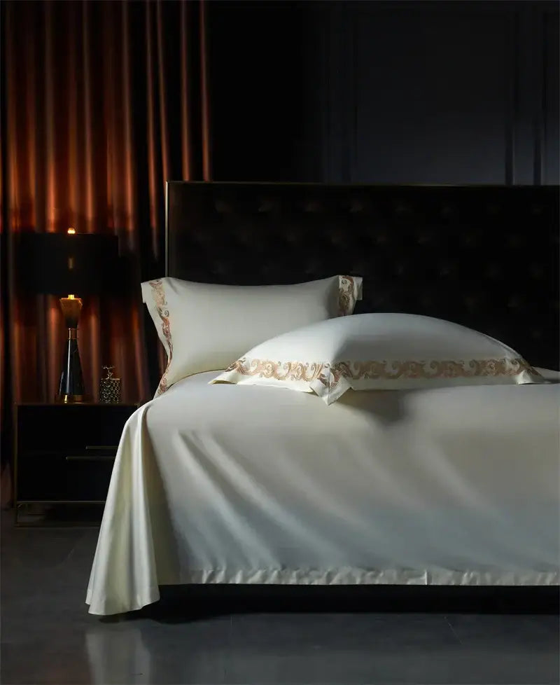 Cream-colored satin bedding set with gold-toned luxe gold embroidery on pillowcases by decorbites luxe gold