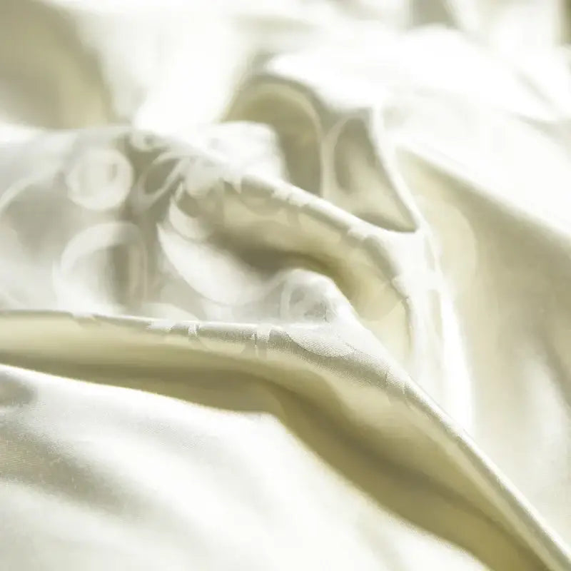 Cream-colored satin fabric with subtle floral pattern on decorbites luxe goose duck down quilt for queen and king size beds