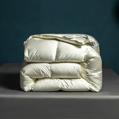 Cream-colored satin-finish quilt with subtle floral embroidery and puffy design in decorbites luxe goose duck down quilt