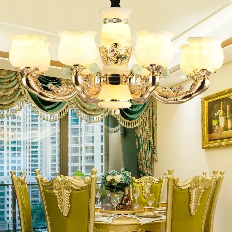 A luxurious gold-toned decorbites luxe jade copper living room chandelier with ornate floral detailing and frosted glass shades