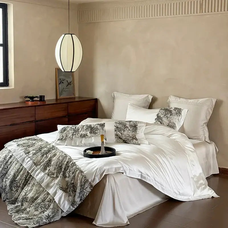 White satin duvet set with layered ruffles and gray botanical print pillows from decorbites luxe lace ruffles bedding set