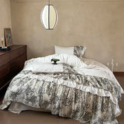 Decorbites luxe lace ruffles bedding set featuring a layered bedspread with gray botanical print on off-white satin base