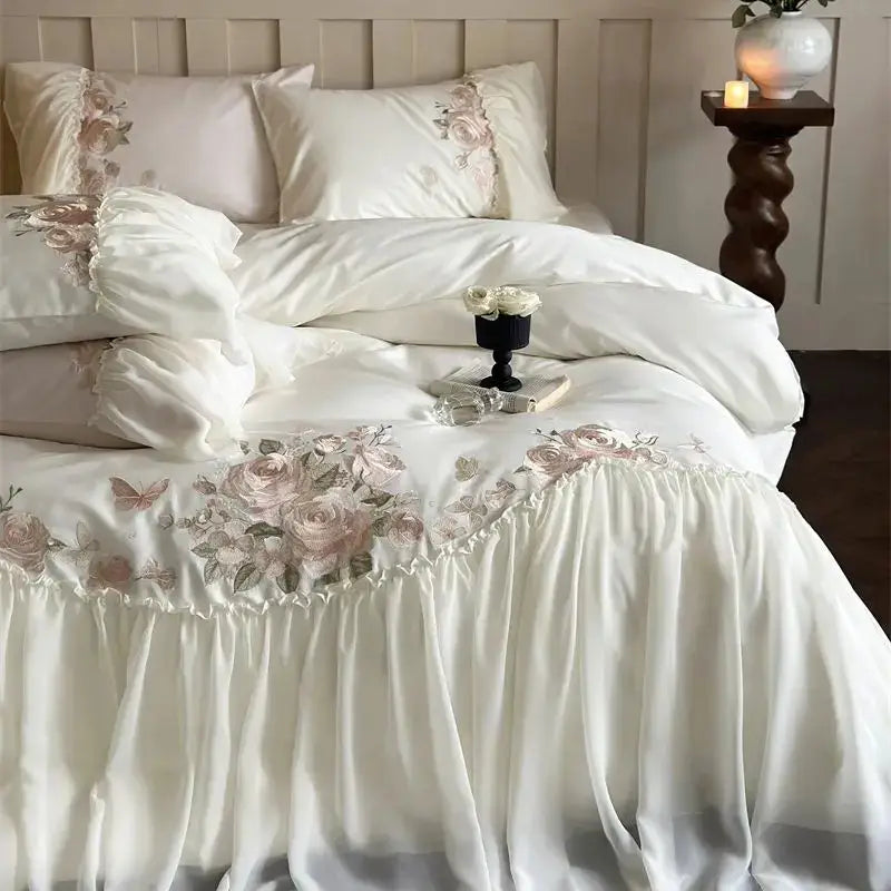 Ivory satin bedding set with blush pink and muted green floral embroidery and ruffled edges from DecorBites luxe lace