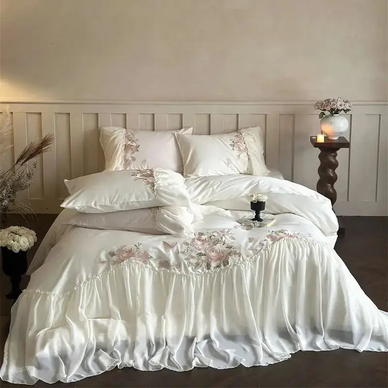 White satin bedding set with delicate pink floral embroidery and ruffled edges from decorbites luxe lace ruffles collection