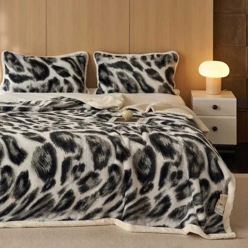 A black and white leopard-print fleece blanket with soft plush texture from decorbites luxe leopard rabbit fur collection