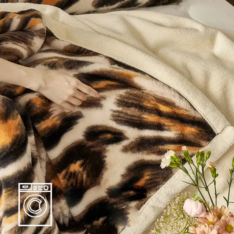 A decorbites luxe leopard cream fleece blanket with bold brown and orange tiger stripes for cozy office and sofa use