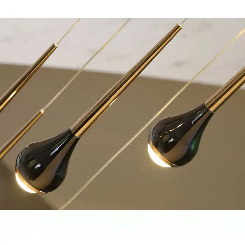 Black glossy teardrop pendant lights with gold-toned stems in decorbites luxe loft chandelier for modern living spaces