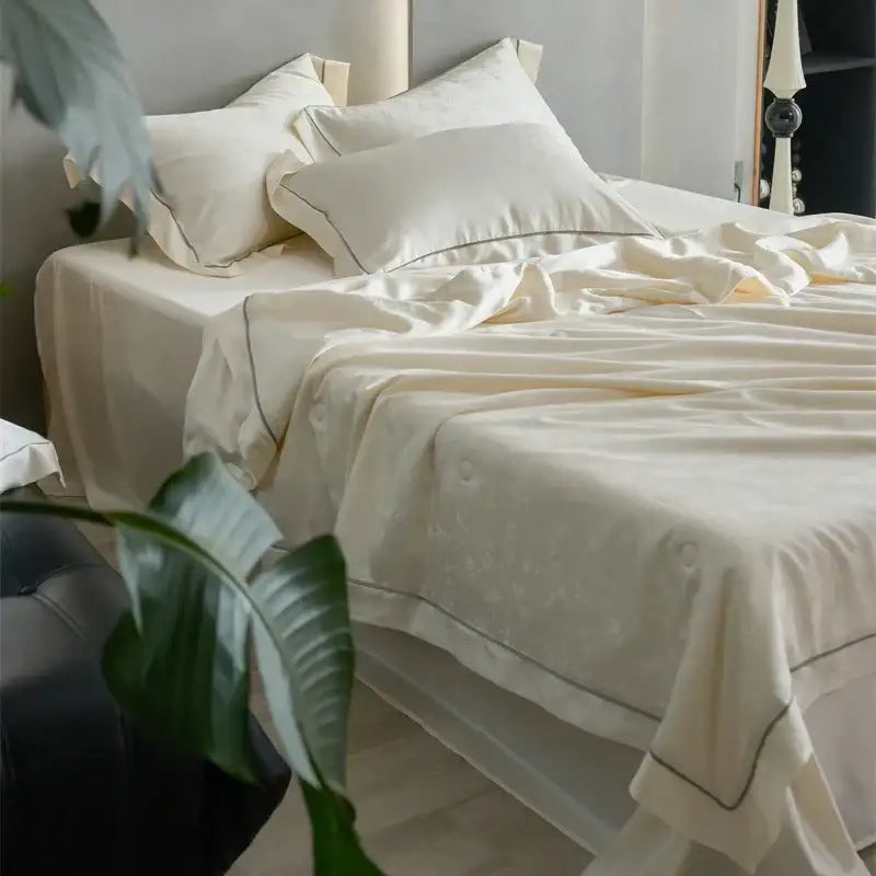 Cream-colored decorbites luxe lyocell summer blanket with mulberry silk fill comforter featuring satin fabric and dark piping edges