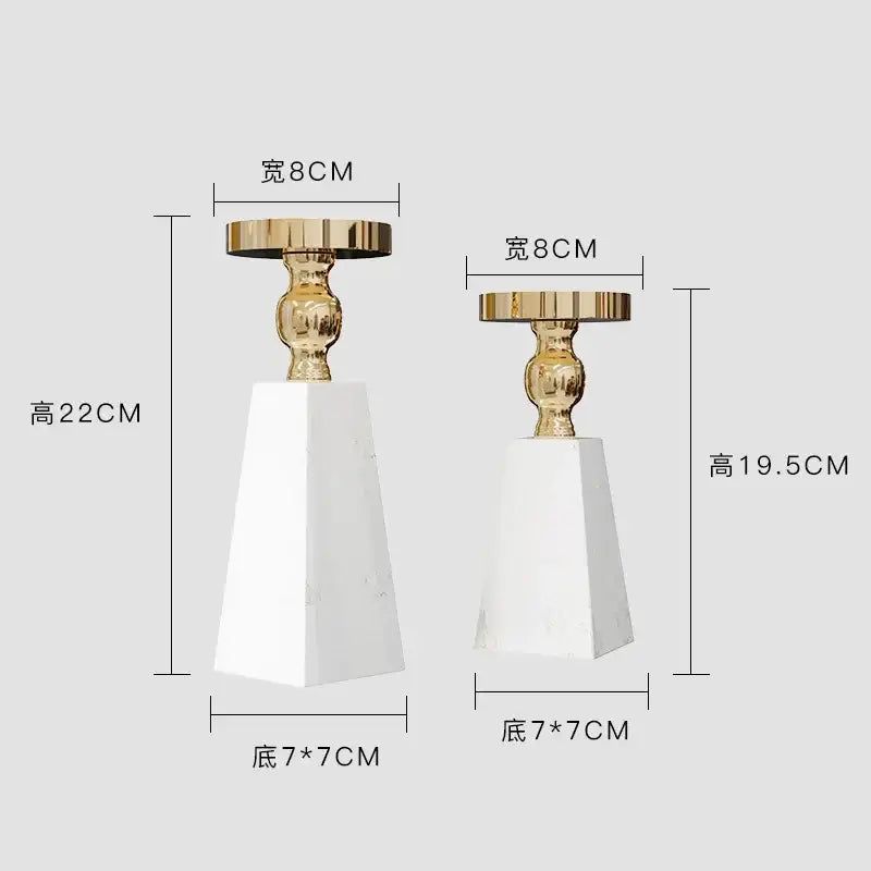 Two elegant candle holders with white marble bases and gold-toned tops in modern minimalist marble candle holder style