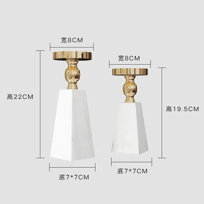 Two elegant candle holders with white marble bases and gold-toned tops in modern minimalist marble candle holder style