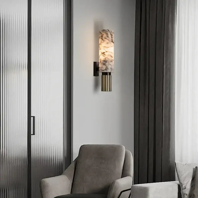 A modern decorbites luxe marble wall lamp with cylindrical marble glass shade and brushed brass base for home décor