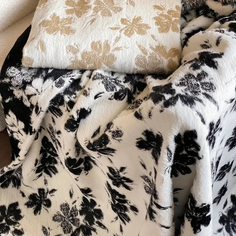 A plush black and white floral-patterned decorbites luxe mink fur jacquard throw with a soft textured surface