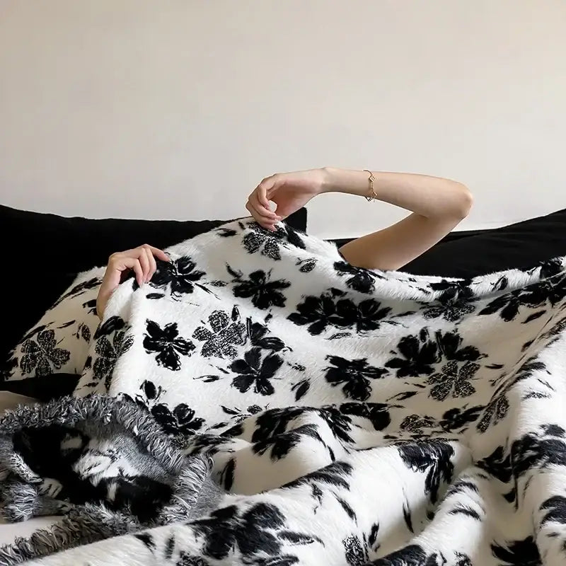White plush decorbites luxe mink fur jacquard throw with black floral patterns and cozy textured surface