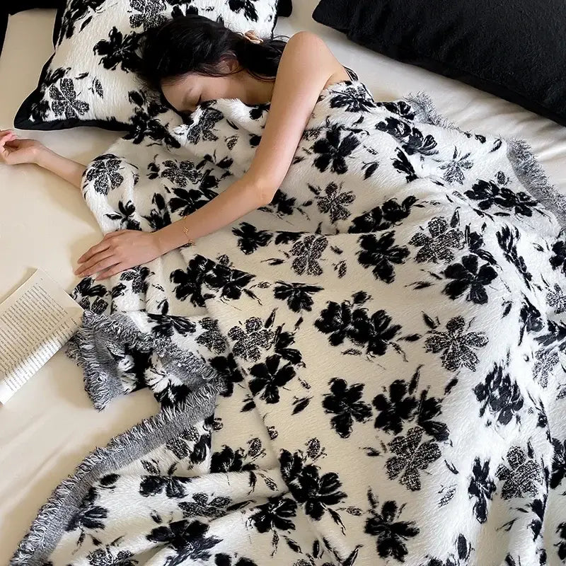 White plush decorbites luxe mink fur jacquard throw with black floral patterns and fringed edges for cozy warmth and style