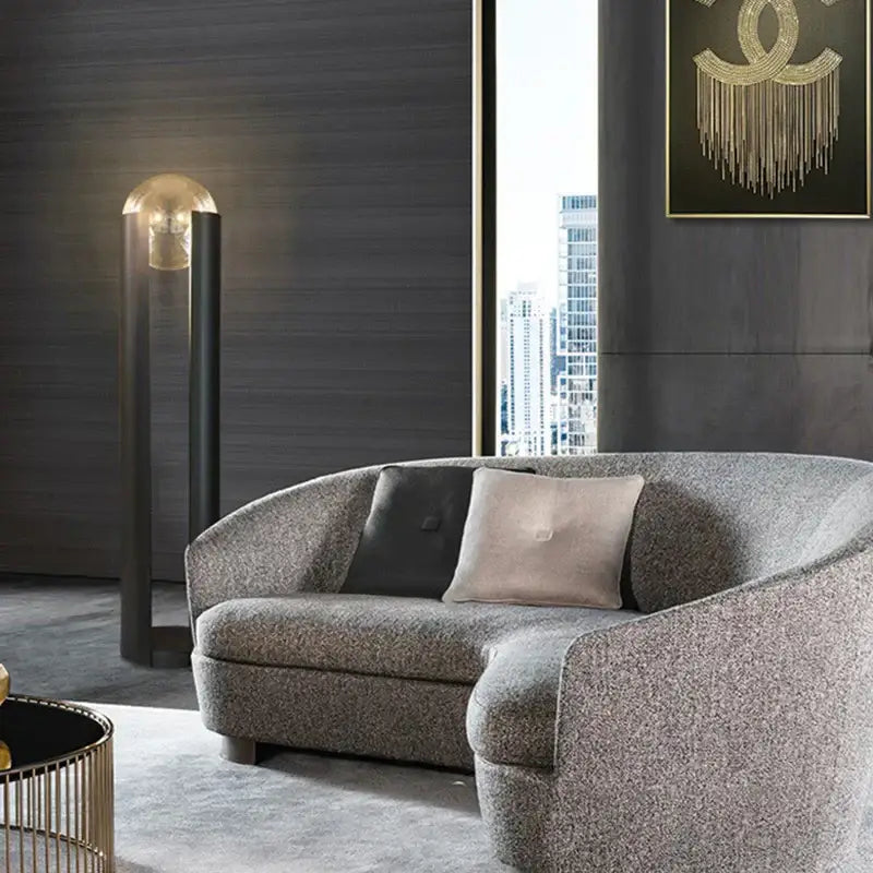 Modern gray textured fabric sofa with curved design and pillows next to decorbites luxe nordic led floor lamp