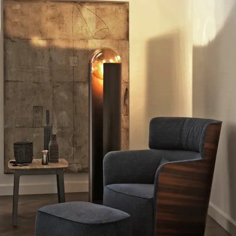 Dark blue velvet armchair with wooden frame and curved design paired with decorbites luxe nordic led floor lamp