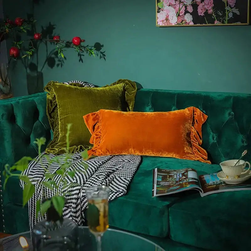 Emerald green velvet sofa with luxe orange velvet ruffled euro pillow sham and olive ruffled pillow sham accents