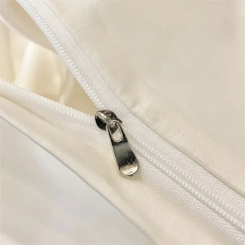 Silver zipper pull on white fabric seam of DecorBites™ luxurious 1000TC Egyptian cotton duvet cover or fitted sheet