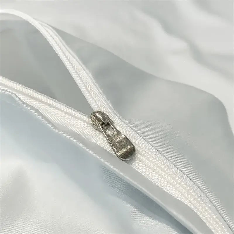 Silver-toned zipper pull on white satin-like fabric of decorbites luxurious 1000tc egyptian cotton duvet cover